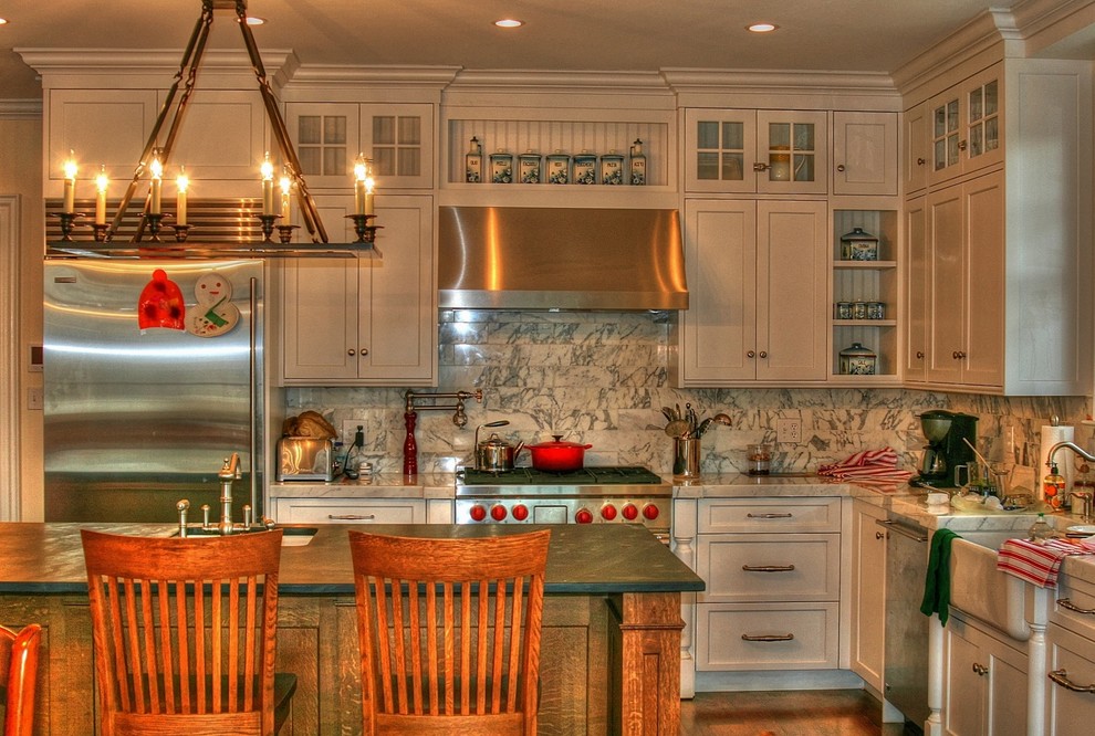 Cette image montre une cuisine traditionnelle avec un placard avec porte à panneau encastré, des portes de placard beiges, une crédence grise et un électroménager en acier inoxydable.