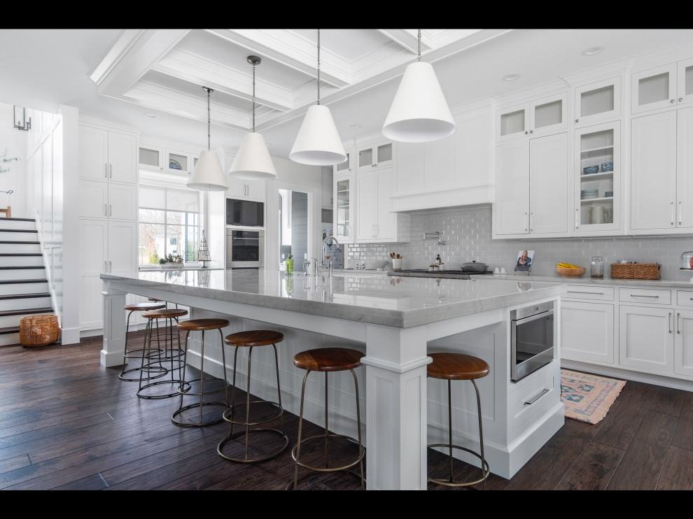 Example of a large farmhouse u-shaped dark wood floor open concept kitchen design in Other with recessed-panel cabinets, white cabinets, marble countertops, white backsplash, subway tile backsplash, stainless steel appliances, an island and white countertops