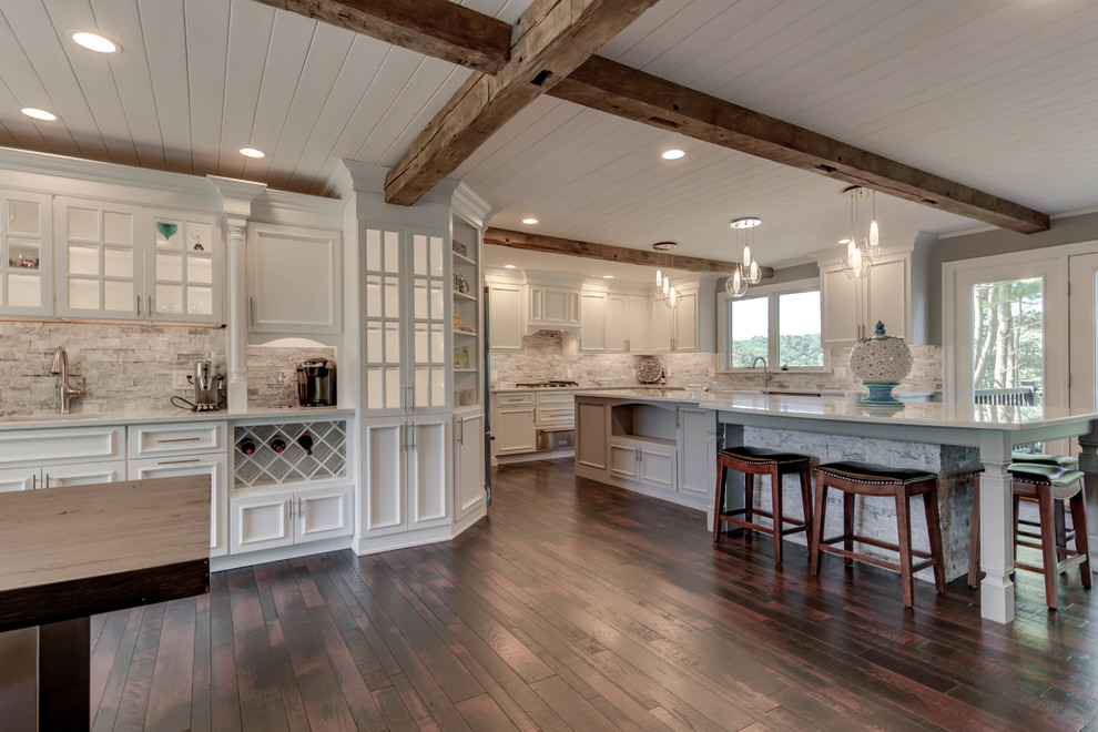 Idéer för att renovera ett lantligt vit vitt kök och matrum, med en rustik diskho, luckor med upphöjd panel, vita skåp, granitbänkskiva, vitt stänkskydd, stänkskydd i stenkakel, rostfria vitvaror, mörkt trägolv, en köksö och brunt golv