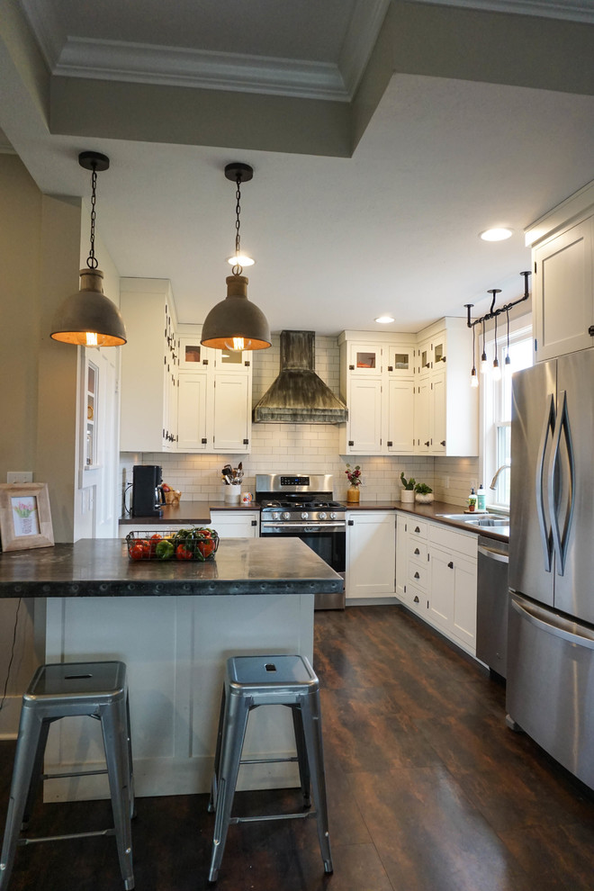 Small farmhouse u-shaped kitchen pantry in Columbus with a built-in sink, shaker cabinets, white cabinets, white splashback, metro tiled splashback, stainless steel appliances, dark hardwood flooring, an island, brown floors and zinc worktops.