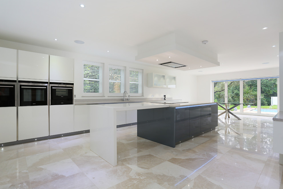 Photo of a contemporary kitchen in London with glass-front cabinets and quartz worktops.