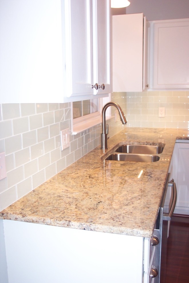 Immagine di una cucina chic con lavello sottopiano, ante bianche, paraspruzzi bianco, paraspruzzi con piastrelle di vetro e elettrodomestici in acciaio inossidabile