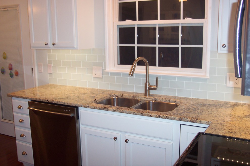 Example of a classic l-shaped eat-in kitchen design in Other with an undermount sink, white cabinets, white backsplash, glass tile backsplash and stainless steel appliances
