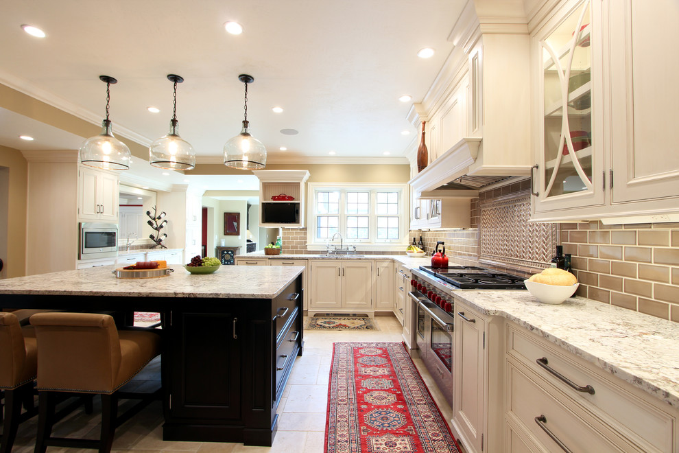 Exempel på ett avskilt, mycket stort klassiskt u-kök, med en undermonterad diskho, luckor med profilerade fronter, vita skåp, granitbänkskiva, beige stänkskydd, stänkskydd i keramik, travertin golv, en köksö, beiget golv och rostfria vitvaror