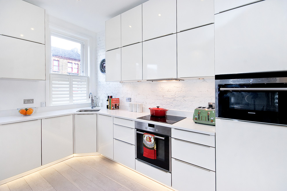 Contemporary kitchen in London with white splashback.