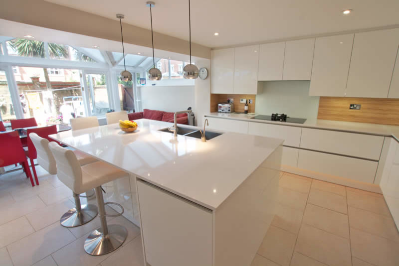 Photo of a modern kitchen in London with white cabinets and an island.