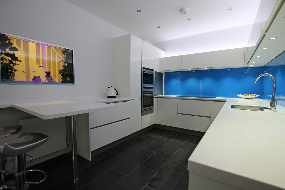 Design ideas for a modern u-shaped kitchen in London with white cabinets.