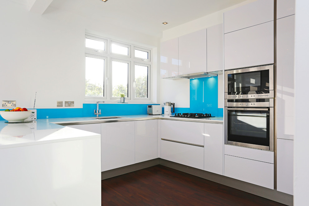 ロンドンにある広いコンテンポラリースタイルのおしゃれなキッチン (ガラス扉のキャビネット、白いキャビネット、シルバーの調理設備) の写真
