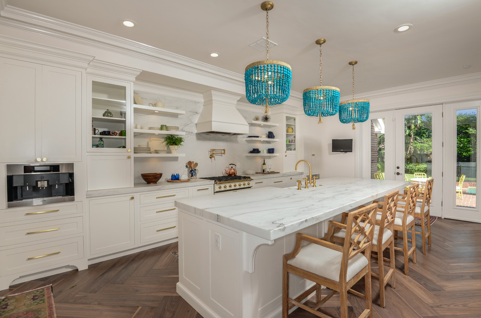 Idées déco pour une cuisine parallèle classique avec un placard à porte shaker, des portes de placard blanches, une crédence blanche, un sol en bois brun, îlot et un sol marron.