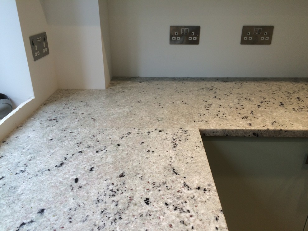 Immagine di una grande cucina minimal con lavello a doppia vasca, top in granito, paraspruzzi grigio e paraspruzzi con lastra di vetro