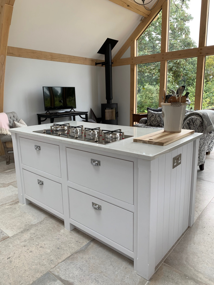 Design ideas for a classic l-shaped kitchen/diner in Surrey with beaded cabinets, white cabinets, quartz worktops, an island and white worktops.