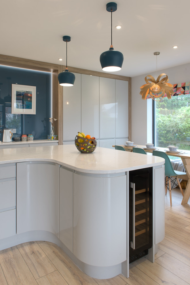 White high gloss curved Island with glass sheet dusk blue splash back ...