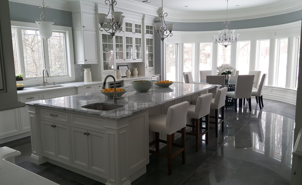 Eat-in kitchen - huge traditional u-shaped gray floor eat-in kitchen idea in New York with an undermount sink, beaded inset cabinets, white cabinets, quartzite countertops, white backsplash, marble backsplash, stainless steel appliances and an island