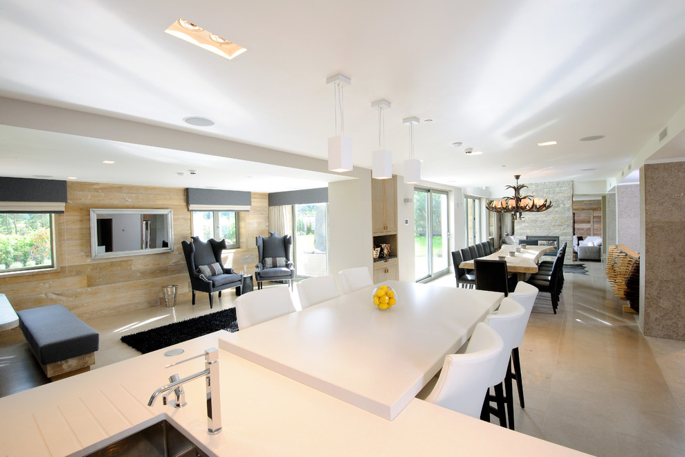 Large trendy l-shaped limestone floor eat-in kitchen photo in Cheshire with an undermount sink, flat-panel cabinets, white cabinets, solid surface countertops, white backsplash, stone slab backsplash, stainless steel appliances and two islands