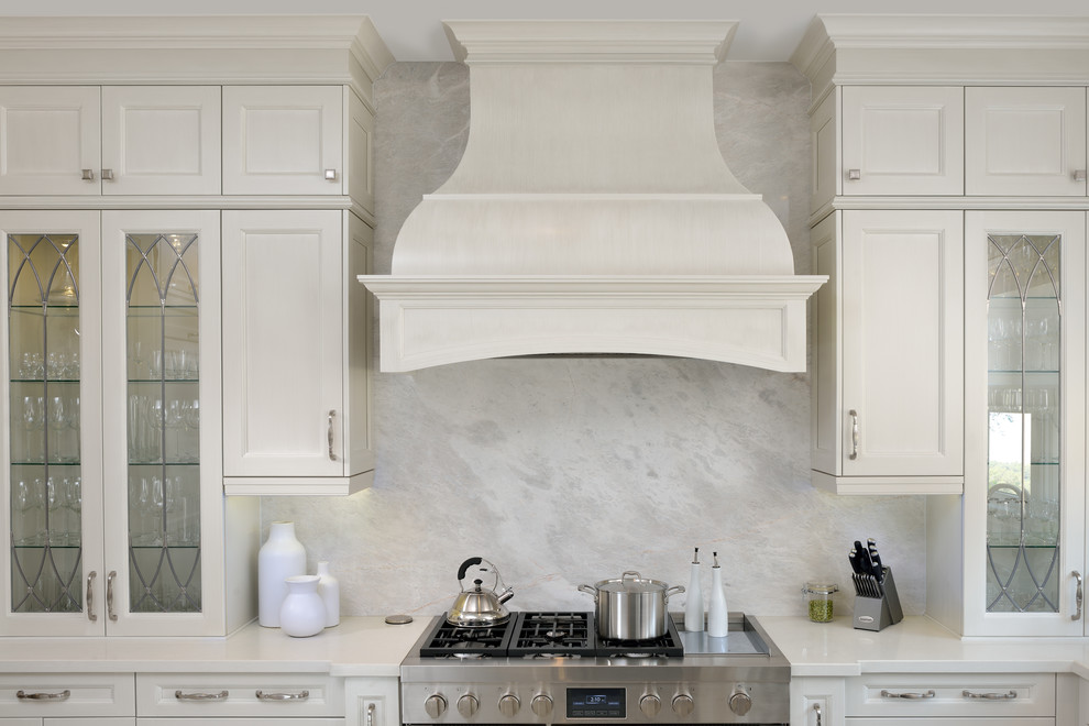 Inspiration for a large transitional l-shaped eat-in kitchen remodel in Toronto with an undermount sink, recessed-panel cabinets, white cabinets, marble countertops, gray backsplash, stone slab backsplash, stainless steel appliances and an island