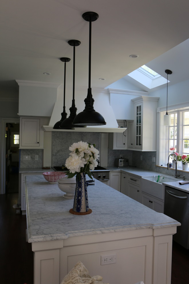 Inspiration for a mid-sized farmhouse l-shaped dark wood floor eat-in kitchen remodel in New York with a farmhouse sink, beaded inset cabinets, white cabinets, marble countertops, white backsplash, stone slab backsplash, stainless steel appliances and an island