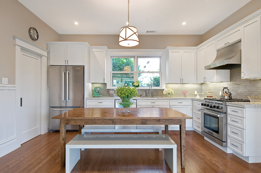 Bild på ett litet funkis kök, med vita skåp, rostfria vitvaror, beige stänkskydd, en undermonterad diskho, luckor med infälld panel, marmorbänkskiva, stänkskydd i keramik, mellanmörkt trägolv, en köksö och brunt golv