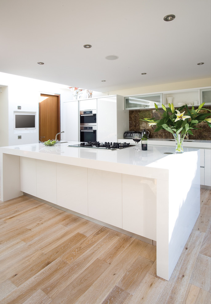 Contemporary kitchen in Other with flat-panel cabinets, white cabinets, brown splashback and stone slab splashback.