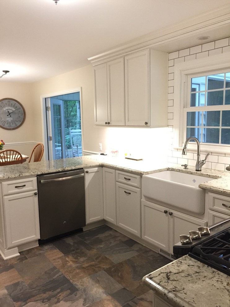 Inredning av ett klassiskt mellanstort kök, med en rustik diskho, luckor med infälld panel, vita skåp, granitbänkskiva, vitt stänkskydd, stänkskydd i keramik, rostfria vitvaror, klinkergolv i porslin, en halv köksö och flerfärgat golv