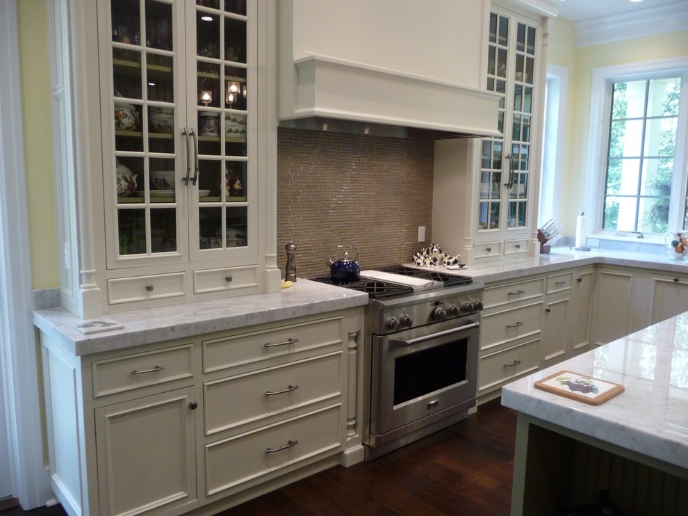 Mid-sized transitional u-shaped dark wood floor eat-in kitchen photo in New York with recessed-panel cabinets, white cabinets, marble countertops, brown backsplash, porcelain backsplash and stainless steel appliances