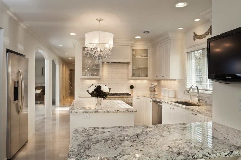 Inspiration for a mid-sized transitional u-shaped marble floor enclosed kitchen remodel in Detroit with an undermount sink, beaded inset cabinets, white cabinets, marble countertops, white backsplash, subway tile backsplash, stainless steel appliances and an island
