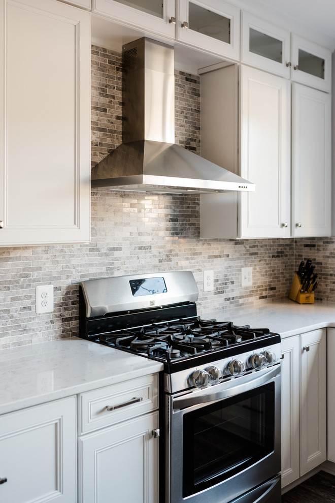 Eat-in kitchen - mid-sized traditional u-shaped vinyl floor and gray floor eat-in kitchen idea in Baltimore with an undermount sink, white cabinets, quartz countertops, ceramic backsplash, stainless steel appliances, an island, white countertops and raised-panel cabinets