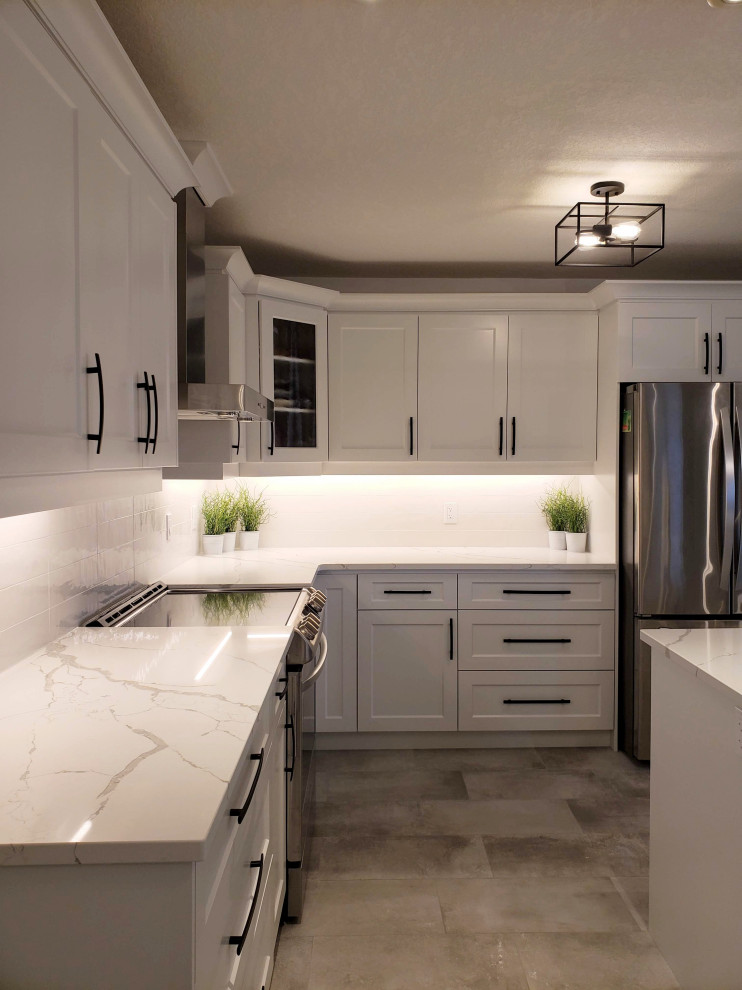 Photo of a medium sized classic l-shaped kitchen/diner in Toronto with recessed-panel cabinets, white cabinets, quartz worktops, white splashback, metro tiled splashback, stainless steel appliances, porcelain flooring, an island, grey floors and white worktops.