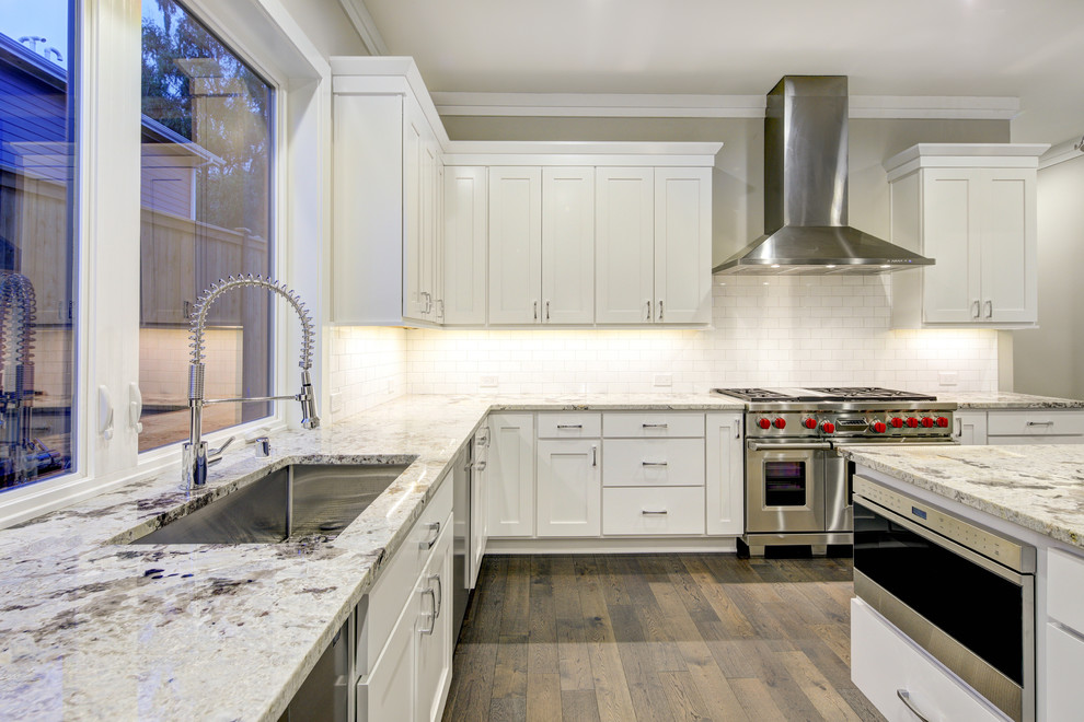 Large minimalist dark wood floor and gray floor eat-in kitchen photo in DC Metro with an undermount sink, shaker cabinets, white cabinets, granite countertops, white backsplash, ceramic backsplash, stainless steel appliances, an island and white countertops