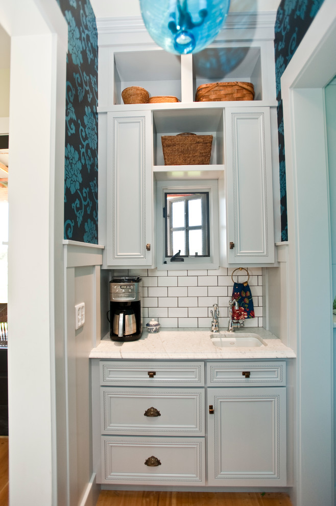 Rural l-shaped kitchen/diner in Other with a submerged sink, flat-panel cabinets, brown cabinets, granite worktops, white splashback, metro tiled splashback and stainless steel appliances.