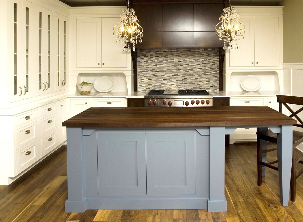 Mid-sized elegant l-shaped medium tone wood floor kitchen photo in Tampa with shaker cabinets, white cabinets, wood countertops, multicolored backsplash and matchstick tile backsplash
