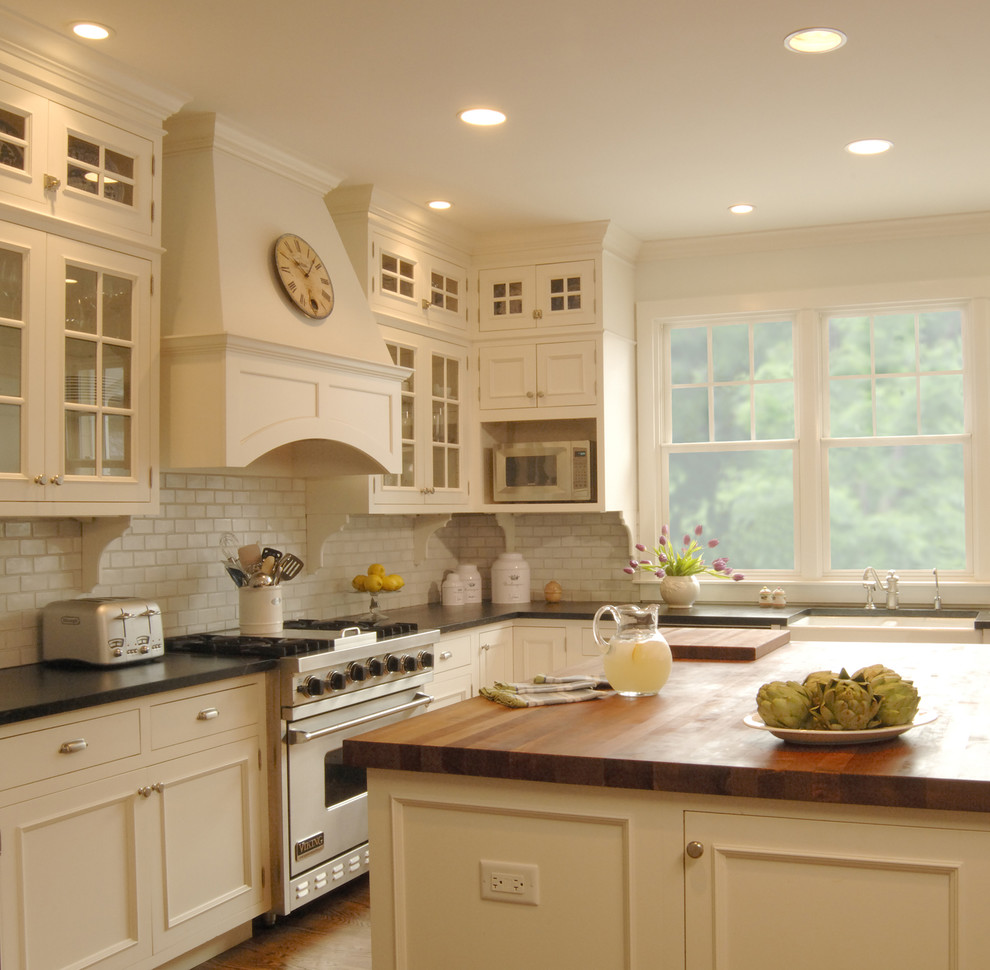 Example of a classic kitchen design in Chicago with soapstone countertops and white appliances