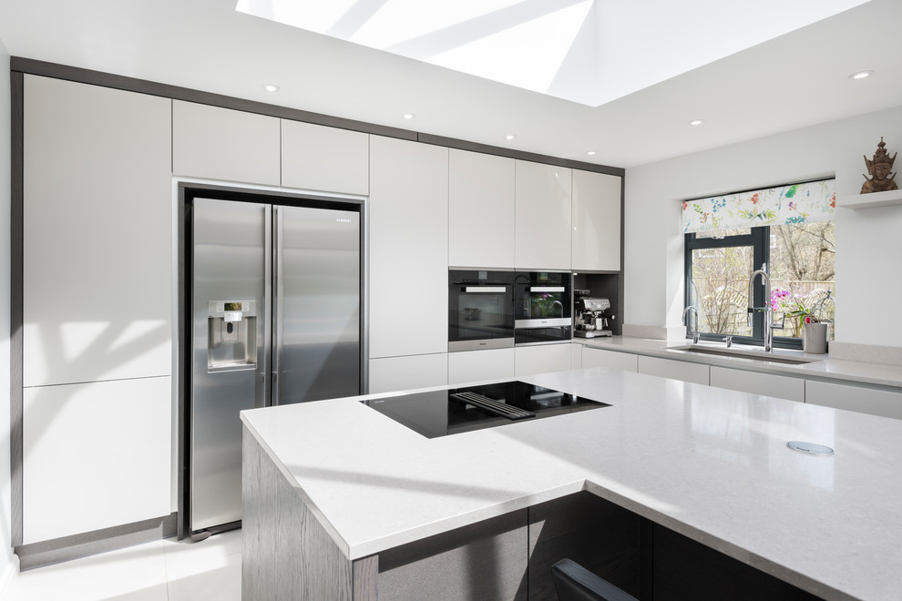Esempio di una cucina moderna di medie dimensioni con ante lisce, ante bianche, top in quarzite, elettrodomestici neri, top grigio, lavello da incasso, pavimento con piastrelle in ceramica e pavimento bianco