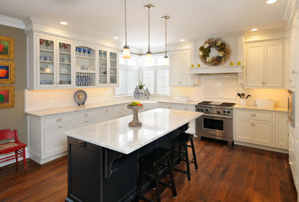 Large transitional u-shaped medium tone wood floor and brown floor enclosed kitchen photo in Boston with shaker cabinets, white cabinets, marble countertops, an island, a farmhouse sink, white backsplash, subway tile backsplash and stainless steel appliances
