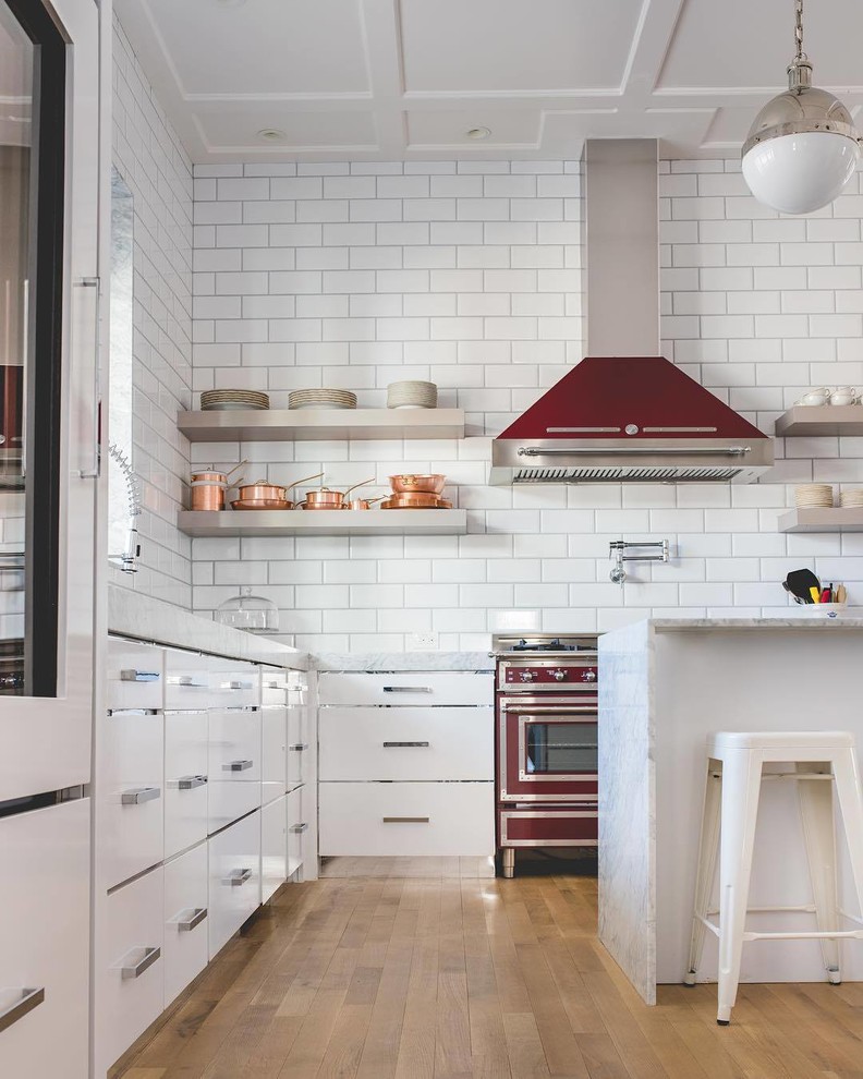 Modern inredning av ett stort l-kök, med släta luckor, vita skåp, marmorbänkskiva, vitt stänkskydd, stänkskydd i porslinskakel, färgglada vitvaror, plywoodgolv och en köksö