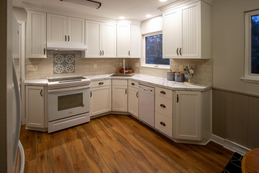 Inspiration för små klassiska vitt kök, med en undermonterad diskho, luckor med infälld panel, vita skåp, laminatbänkskiva, beige stänkskydd, stänkskydd i porslinskakel, vita vitvaror, vinylgolv och brunt golv