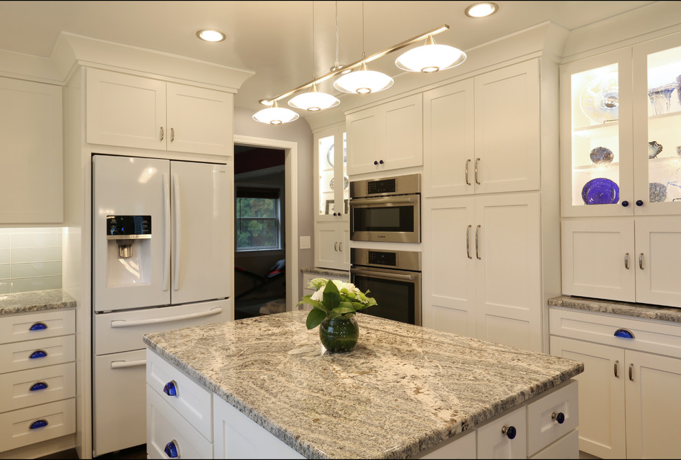 Idéer för att renovera ett mellanstort amerikanskt beige beige kök, med en undermonterad diskho, skåp i shakerstil, granitbänkskiva, blått stänkskydd, stänkskydd i glaskakel, vita vitvaror, mörkt trägolv, en köksö och brunt golv