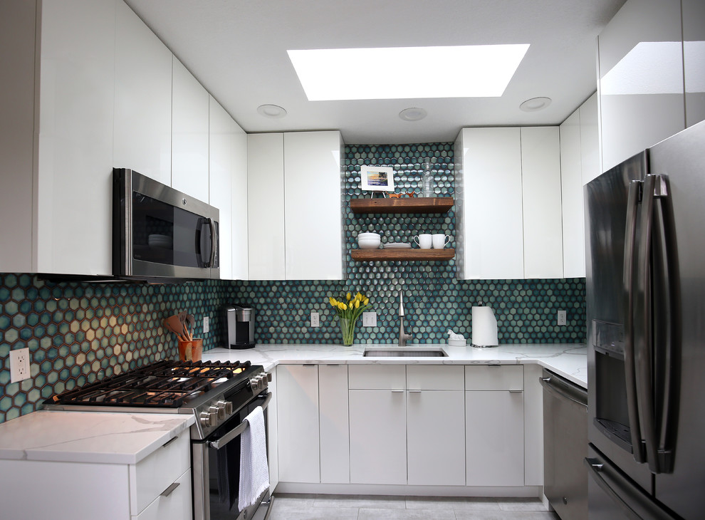 Inspiration for a small mid-century modern u-shaped ceramic tile and gray floor kitchen remodel in Denver with an undermount sink, flat-panel cabinets, white cabinets, quartzite countertops, blue backsplash, porcelain backsplash, stainless steel appliances and white countertops
