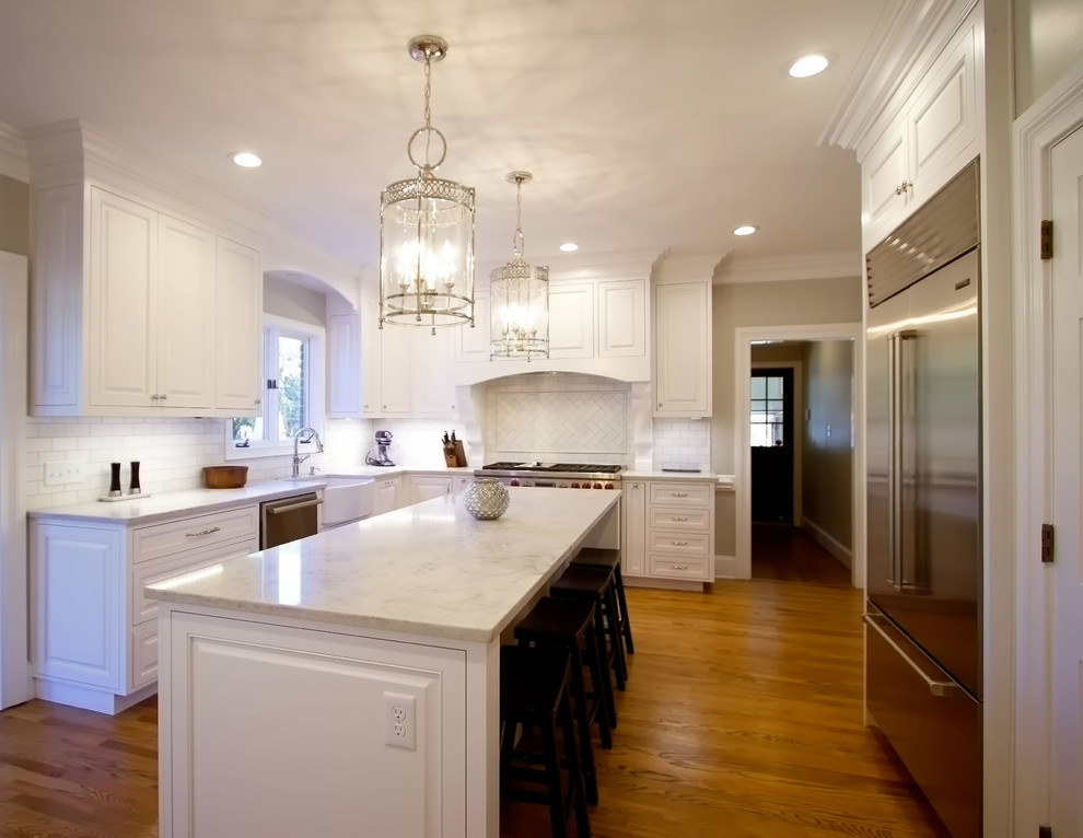 Exempel på ett avskilt, mellanstort klassiskt l-kök, med en rustik diskho, luckor med profilerade fronter, vita skåp, marmorbänkskiva, vitt stänkskydd, stänkskydd i keramik, rostfria vitvaror, ljust trägolv och en köksö