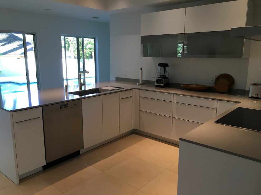 Inspiration for a mid-sized contemporary u-shaped kitchen remodel in Hawaii with a single-bowl sink, flat-panel cabinets, white cabinets, quartz countertops, stainless steel appliances and a peninsula