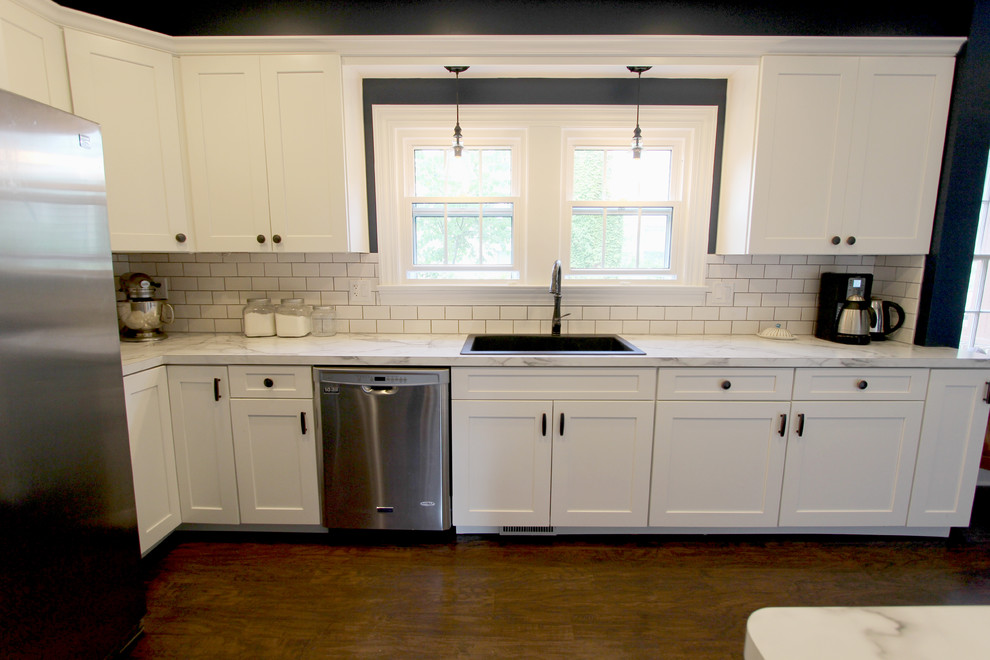 Exempel på ett mellanstort klassiskt kök, med en undermonterad diskho, släta luckor, vita skåp, laminatbänkskiva, vitt stänkskydd, stänkskydd i keramik, vita vitvaror och linoleumgolv