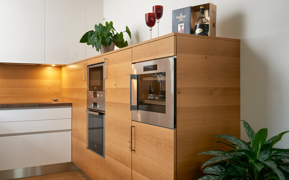 Idéer för ett mellanstort modernt u-kök, med en nedsänkt diskho, släta luckor, vita skåp, laminatbänkskiva, brunt stänkskydd, stänkskydd i trä, rostfria vitvaror och plywoodgolv