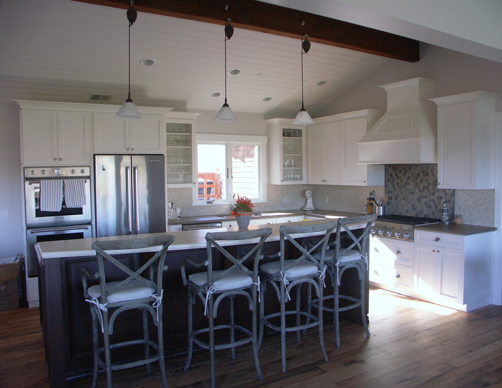 Example of a mid-sized classic l-shaped medium tone wood floor and brown floor eat-in kitchen design in San Francisco with shaker cabinets, white cabinets, stainless steel appliances, an island, an undermount sink, solid surface countertops, gray backsplash and mosaic tile backsplash