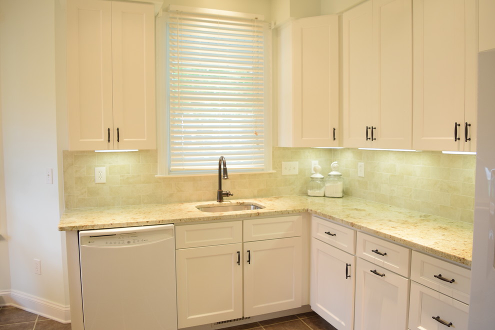 This is an example of a medium sized classic u-shaped kitchen/diner in Baltimore with a submerged sink, flat-panel cabinets, white cabinets, granite worktops, beige splashback, cement tile splashback, white appliances, vinyl flooring and no island.