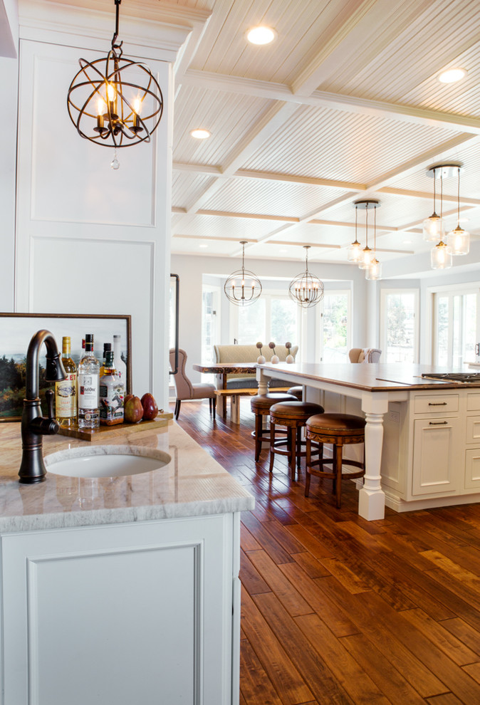 Example of a huge classic u-shaped medium tone wood floor eat-in kitchen design in St Louis with an undermount sink, recessed-panel cabinets, white cabinets, quartz countertops, multicolored backsplash, mosaic tile backsplash, paneled appliances and an island