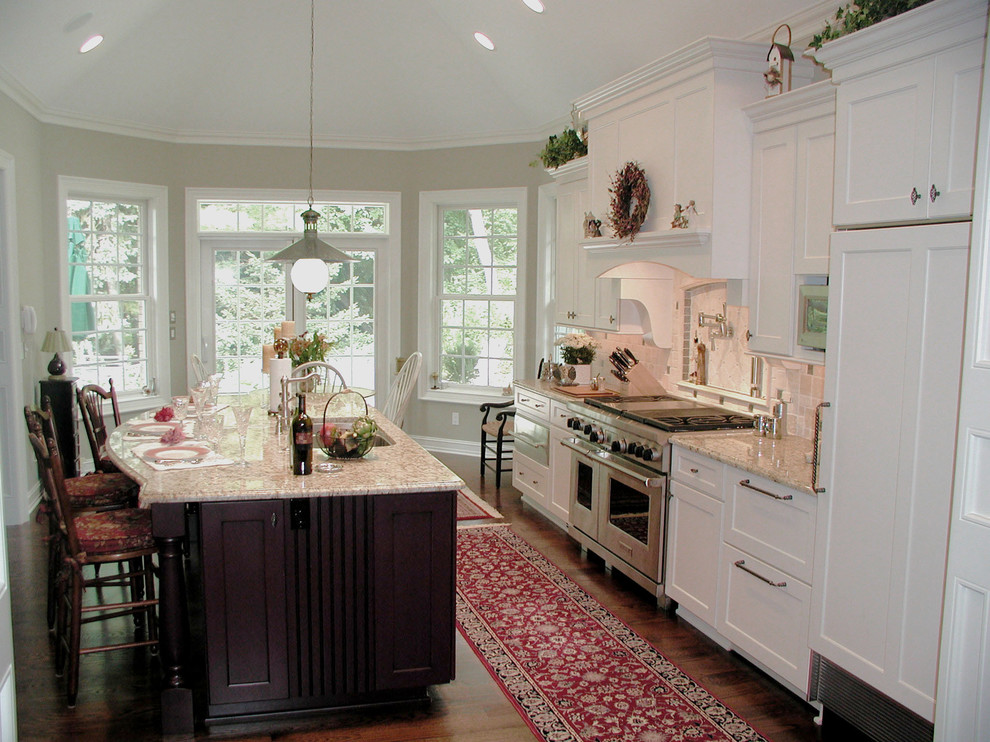 Exempel på ett mellanstort klassiskt kök, med en dubbel diskho, skåp i shakerstil, vita skåp, granitbänkskiva, beige stänkskydd, stänkskydd i stenkakel, integrerade vitvaror, mörkt trägolv och en köksö