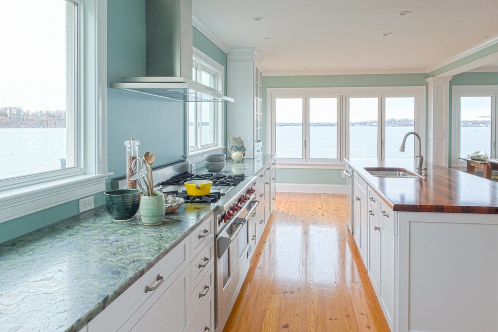 Eat-in kitchen - mid-sized coastal galley medium tone wood floor eat-in kitchen idea in New York with a double-bowl sink, shaker cabinets, white cabinets, granite countertops, blue backsplash, stainless steel appliances and an island