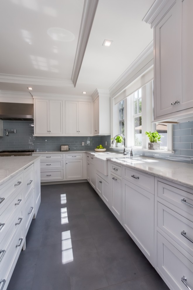 Example of a mid-sized transitional gray floor and ceramic tile eat-in kitchen design in Atlanta with an undermount sink, shaker cabinets, white cabinets, quartzite countertops, gray backsplash, glass tile backsplash, stainless steel appliances, an island and white countertops