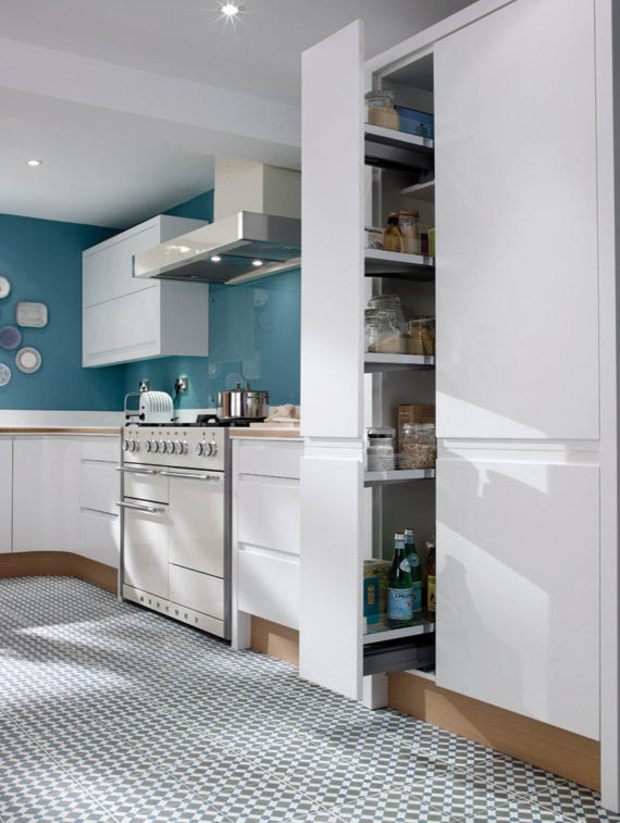 Immagine di una cucina contemporanea di medie dimensioni con lavello sottopiano, ante lisce, ante bianche, top in superficie solida, elettrodomestici colorati e pavimento con piastrelle in ceramica