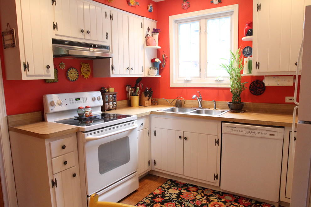 Foto de cocinas en U ecléctico con electrodomésticos blancos, encimera de madera, fregadero encastrado y puertas de armario blancas