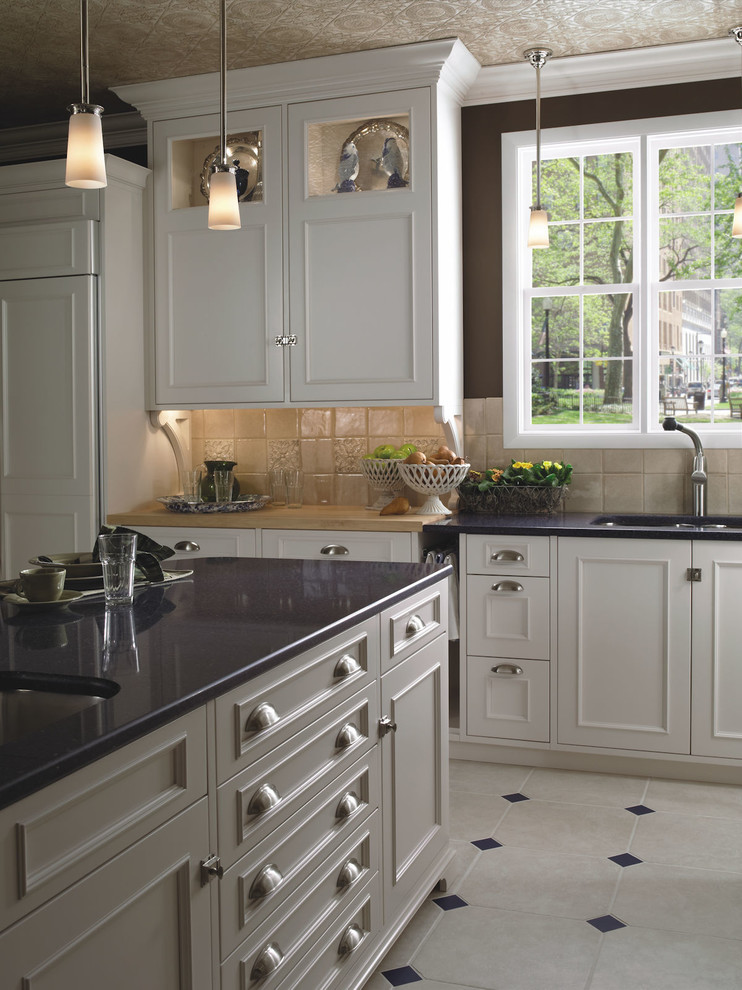 Exempel på ett stort klassiskt svart svart u-kök, med en undermonterad diskho, luckor med upphöjd panel, vita skåp, marmorbänkskiva, beige stänkskydd, stänkskydd i keramik, rostfria vitvaror, marmorgolv, en köksö och vitt golv